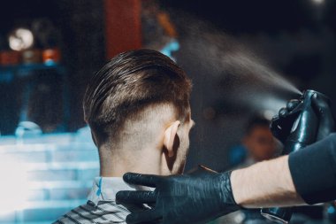 Berber dükkanında oturan şık bir adam.