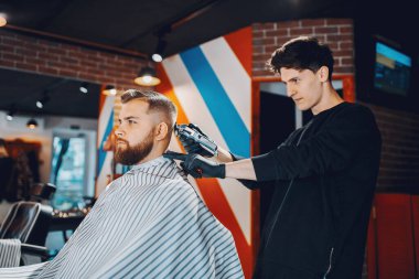 Berber dükkanında oturan şık bir adam.