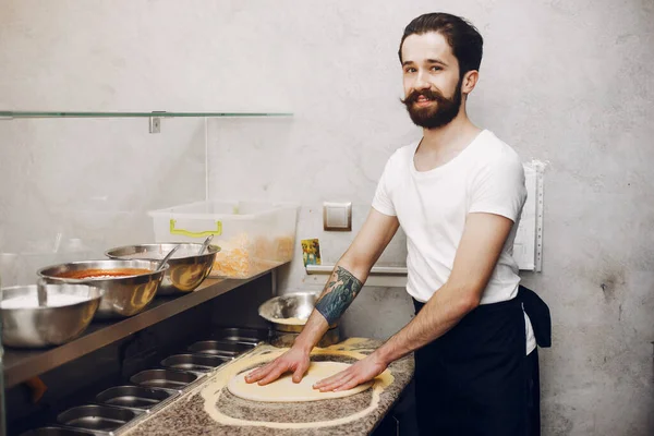 Koch in der Küche bereitet Pizza zu — Stockfoto