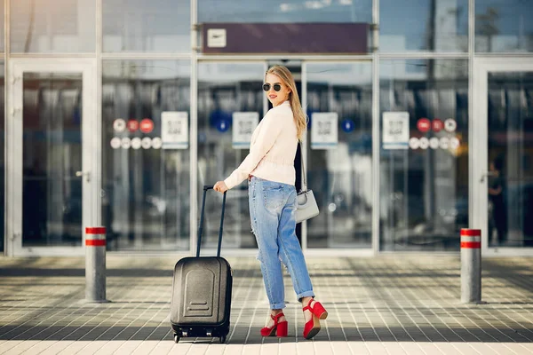 Schönes Mädchen steht auf einem Flughafen — Stockfoto