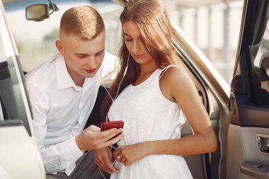 Güzel bir çift, bir yaz parkında bir arabanın yanında vakit geçirir.