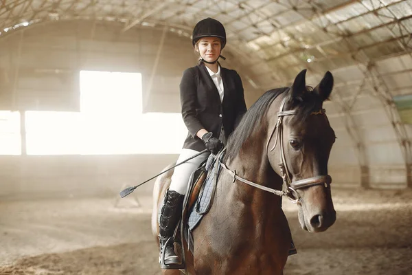Всадник в черной форме тренируется с лошадью — стоковое фото
