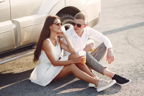 这对年轻漂亮的夫妇在汽车旁边的一个夏季公园里消磨时光 — 图库照片