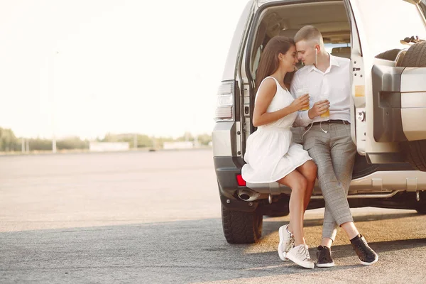 Belo casal passar o tempo em um parque de verão perto de um carro — Fotografia de Stock