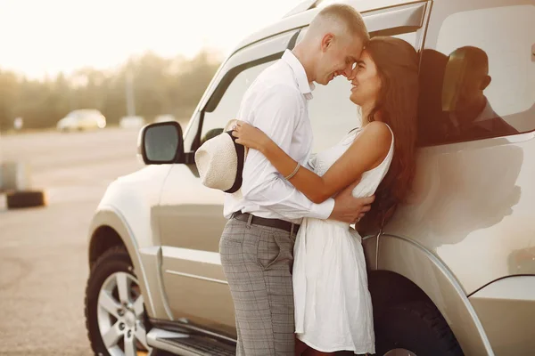 Schönes Paar verbringt Zeit in einem Sommerpark in der Nähe eines Autos — Stockfoto