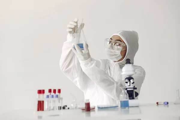 Um cientista de laboratório está examinando a solução azul em uma garrafa — Fotografia de Stock