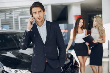 Bir araba galerisinde şık ve zarif insanlar.