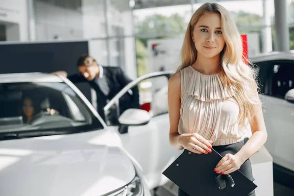 Stylish and elegant people in a car salon — Stock Photo, Image