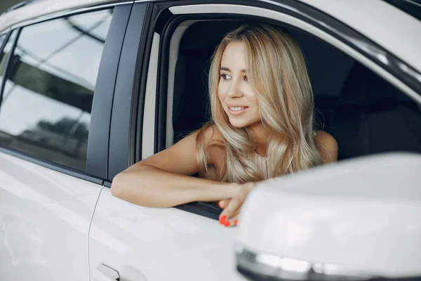 Stylish and elegant woman in a car salon — Stock Photo, Image