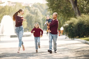 Sonbahar parkında tatlı çocuklu bir aile.