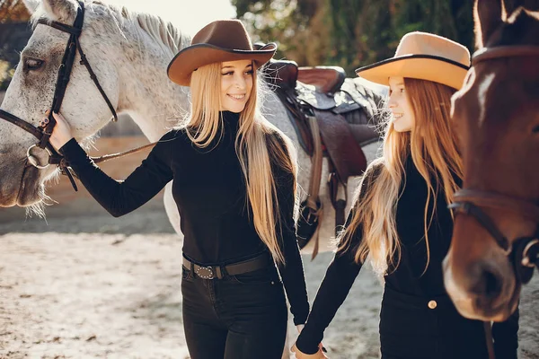 Meninas elegantes com um cavalo em um rancho — Fotografia de Stock