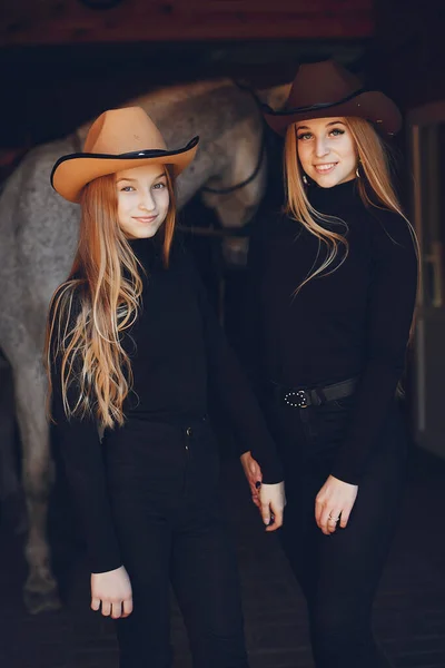 Elegante meisjes met een paard in een ranch — Stockfoto