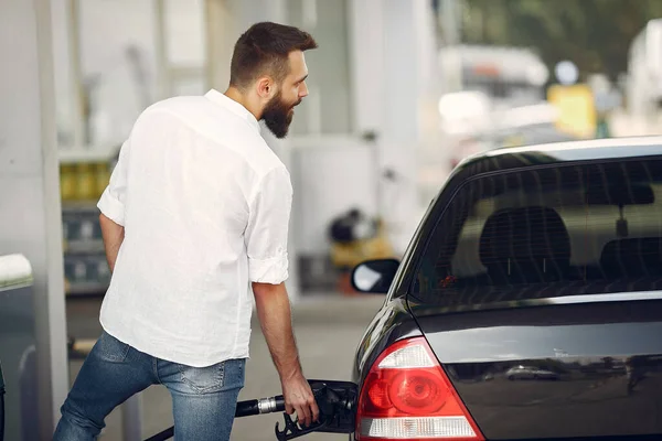 Hombre guapo vierte gasolina en el tanque de coche —  Fotos de Stock