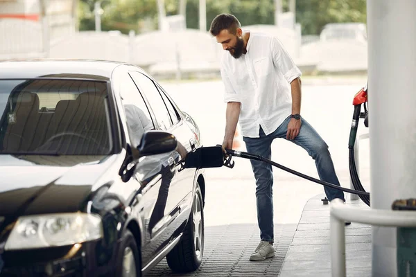 Schöner Mann schüttet Benzin in Tank von Auto — Stockfoto