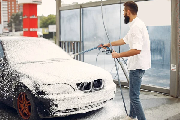 Uomo che lava la sua auto in una stazione di lavaggio — Foto Stock