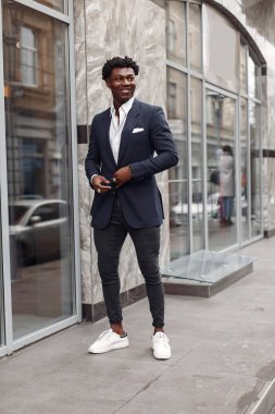 Sonbahar şehrinde siyah takım elbiseli bir zenci.