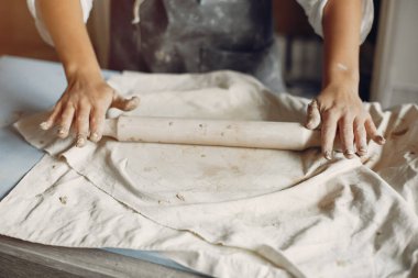 Genç bir kadın çömlekçide bulaşık yapıyor.