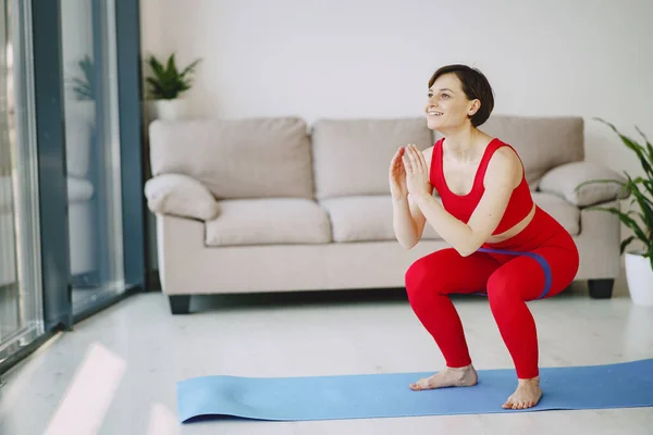 Mädchen in roter Sportuniform machen Yoga zu Hause — Stockfoto