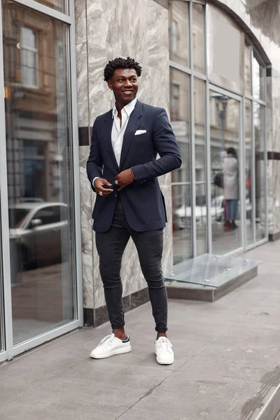 Sonbahar şehrinde siyah takım elbiseli bir zenci.