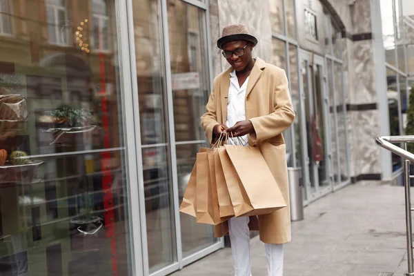 Homem negro elegante em uma cidade com sacos de compras — Fotografia de Stock