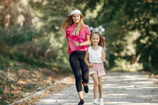 Madre con figlia che fa sport in un parco estivo — Foto Stock