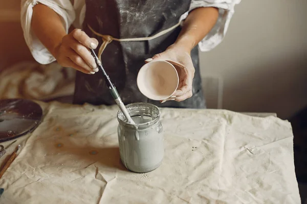 Молодая женщина готовит посуду в керамике — стоковое фото