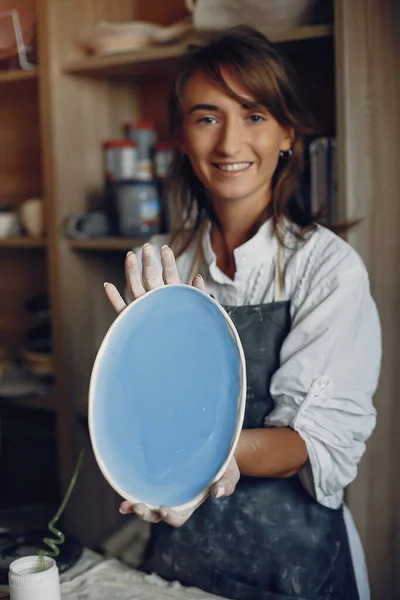 Una giovane donna fa i piatti in una ceramica — Foto Stock