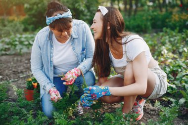 Güzel kadınlar evin yakınındaki bir bahçede çalışırlar.