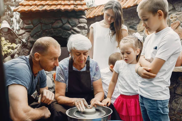 Бабусі і дідусі з онуками роблять глечик в кераміці — стокове фото