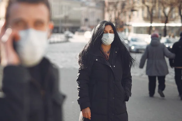 People in a masks stands on the street