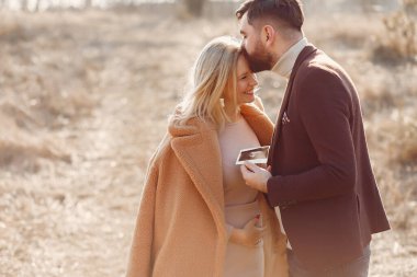 Kocasıyla parkta duran hamile bir kadın.