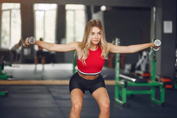 Sport blond i en sportkläder utbildning i ett gym — Stockfoto