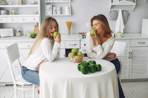 Meninas bonitas e desportivas em uma cozinha com um legumes — Fotografia de Stock