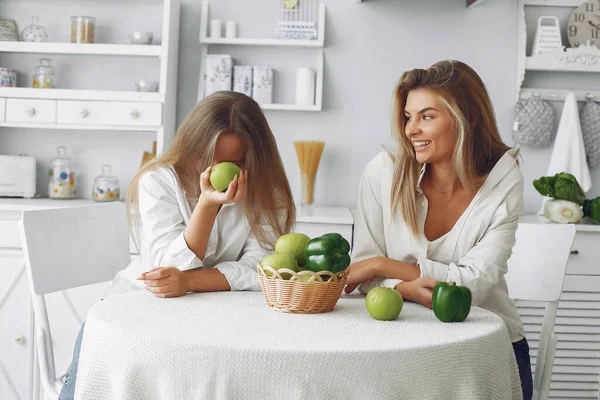 Vackra och sportiga tjejer i ett kök med grönsaker — Stockfoto