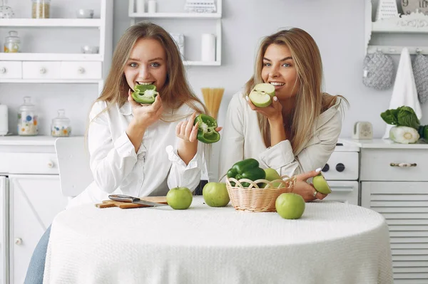Krásné a sportovní dívky v kuchyni se zeleninou — Stock fotografie