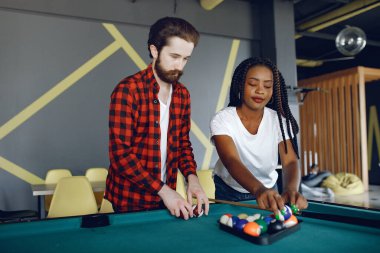 Uluslararası çift bir kulüpte bilardo oynuyor.