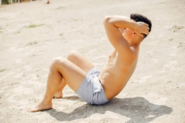 Hombre deportivo entrenando en una playa — Foto de Stock