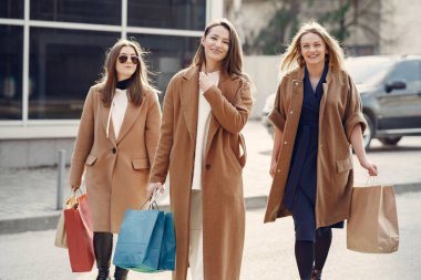 Kadın alışveriş torbalarıyla dışarı çıkıyor.