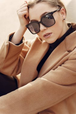 Bahar şehrinde kahverengi ceketli zarif bir kadın.