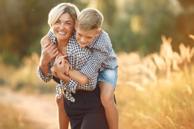 Anne ve küçük oğlu bahar tarlasında yürüyorlar.