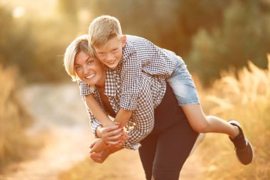 Anne ve küçük oğlu bahar tarlasında yürüyorlar.