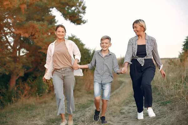 Två mödrar med en ung son som går på ett vårfält — Stockfoto