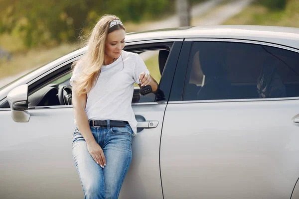 Elegant woman standing by the car — Stock Photo, Image