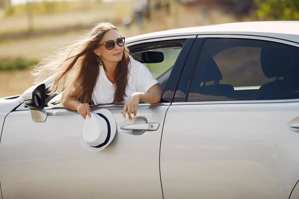 Elegant woman looks out of the car window — Stock Photo, Image