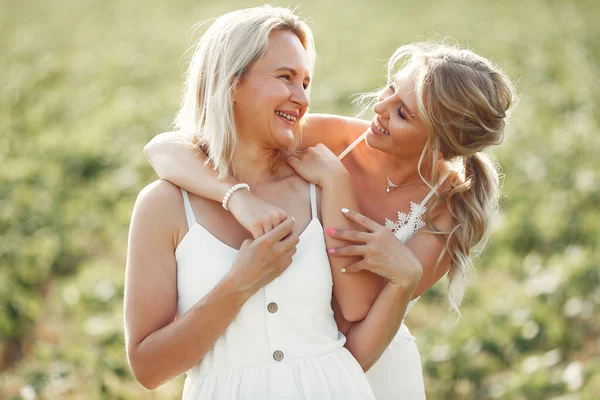 Mother with beautiful daughter in a autumn field — Stock Photo, Image