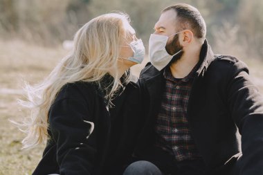 Bahar ormanlarında maskeli insanlar yürür.