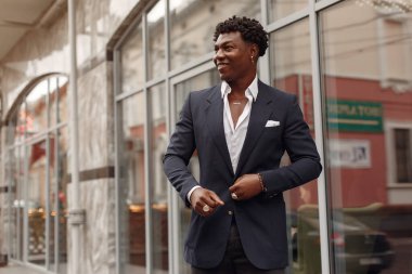 Sonbahar şehrinde siyah takım elbiseli bir zenci.