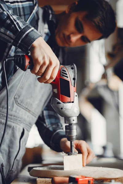 Marangoz bir ağaçla çalışır.