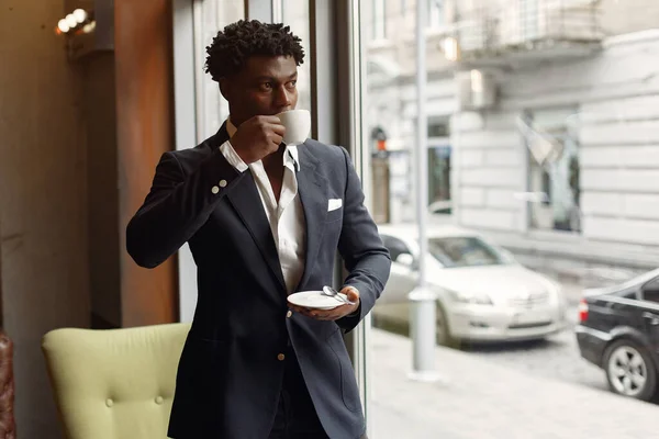 Schwarzer Mann steht in einem Café und trinkt einen Kaffee — Stockfoto
