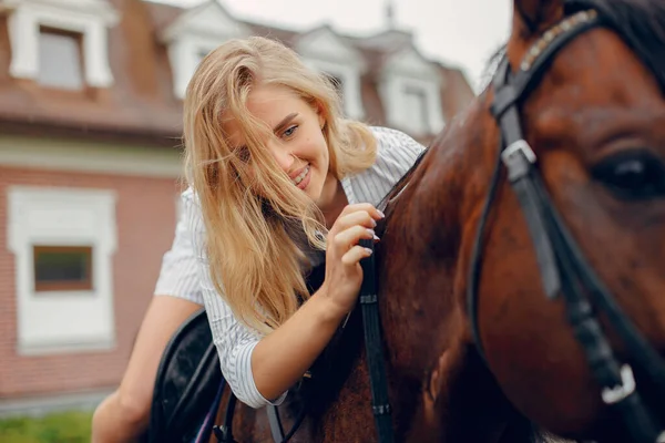 Beautiful woman standing with a horse — Stock Photo, Image